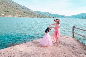 Woman And Child Standing Near Body Of Water