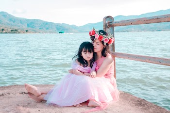 Woman And Girl Sitting Beside Fence