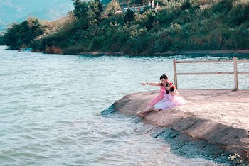 Woman And Girl Sitting Near Sea