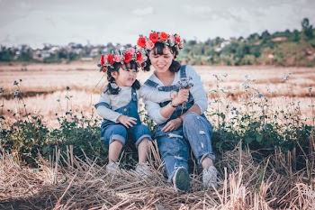 Woman and Girl Sitting on Green Grass