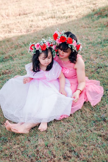 Woman and Girl Sitting on Green Grass Field