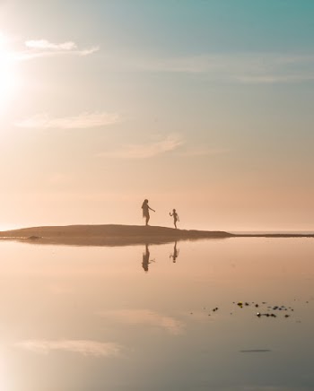 Woman and Girl Standing in Sand Bar