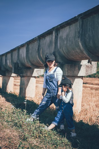Woman and Girl Standing Under Large Sewage