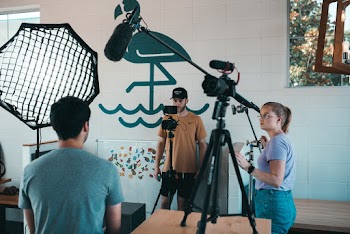 Woman and Man Behind Camera by Man Sitting Infront of Camera