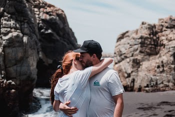 Woman and Man Hugging Each Other Under Cloudy Sky