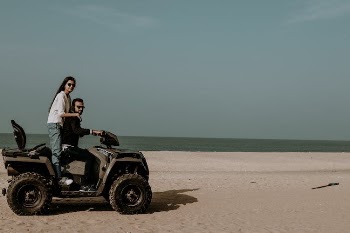 Woman and Man Riding on a Quad on a Beach