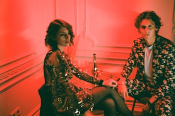 Woman and Man Sitting Near Wall