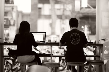 Woman and Man Sitting on a Table By the Window