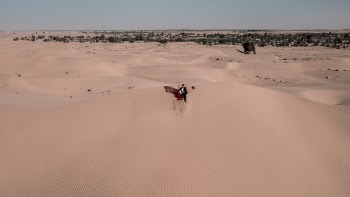 Woman and Man Sitting on Desert