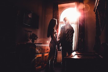 Woman and Man Standing Inside Room Near Window