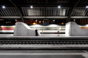 woman and man standing on train station with lights turned on