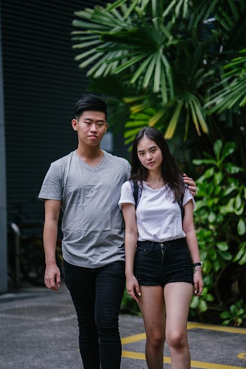Woman and Man Walking Near Green-leafed Plants