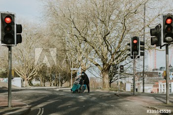 woman and son crossing a street during coronavirus outbreak. BRISTOL, UK, March 30, 2020