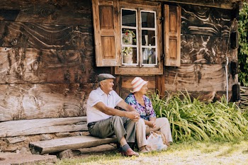 Woman and Woman Sitting on Bench in Front of the Window
