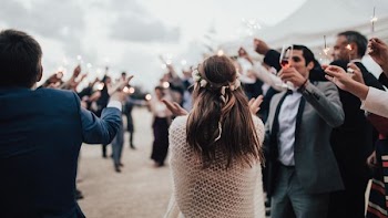 woman approaching a crowd carrying a lighted candle