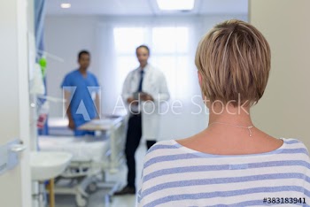 Woman approaching doctors in hospital room