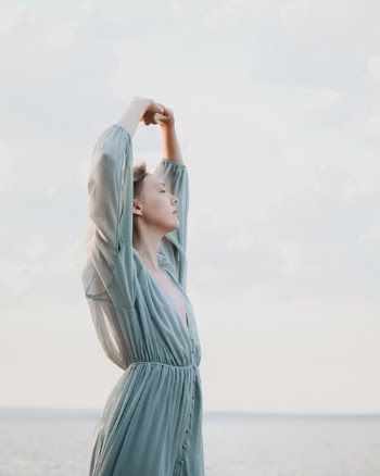 Woman Arms Raised Near Seashore · Free Stock Photo