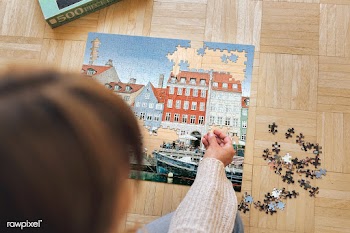 Woman assembling a jigsaw puzzle of Nyhavn, Copenhagen during coronavi.. | Free  photo - 2329911