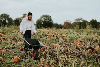 Woman at a pumpkin patch before Halloween