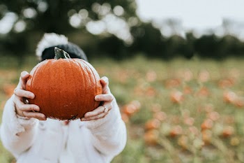 Woman at a pumpkin patch before Halloween