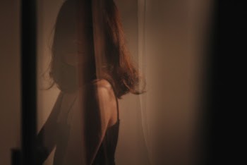 Woman Behind Curtain