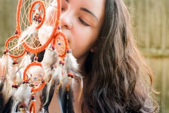woman behind orange nightmare catcher hanging decor