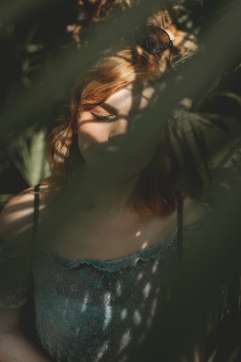 Woman Behind Plants And Touched By Sunlight