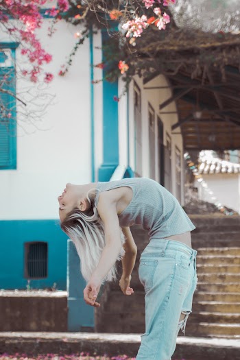 Woman Bending Beside House