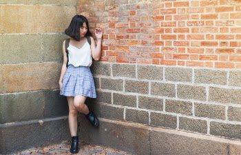 Woman Beside Brick and Cinder Wall