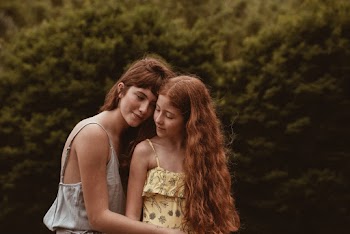 Woman Beside Girl Near Green Tree