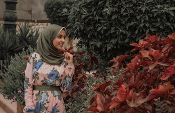 Woman Beside Red Petal Flowers