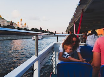 Woman Beside Toddler Boy Sitting on Blue Chair in Boat