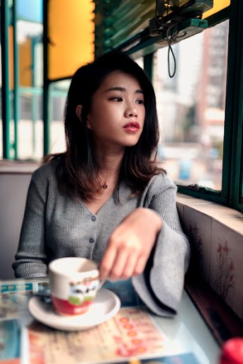 Woman Beside Window Holding Mug