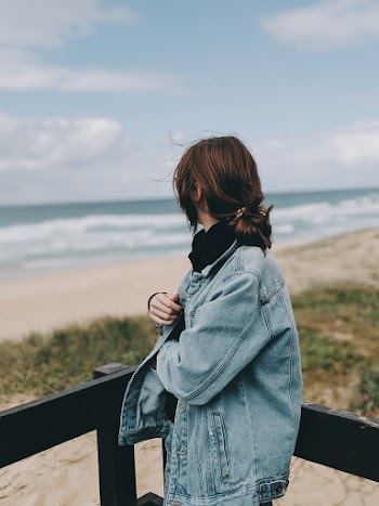 Woman Beside Wooden Handrail Looking at the Ocean