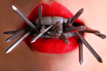 Woman Biting Gray Nails in Her Mouth