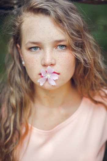 Woman Biting Pink Flower
