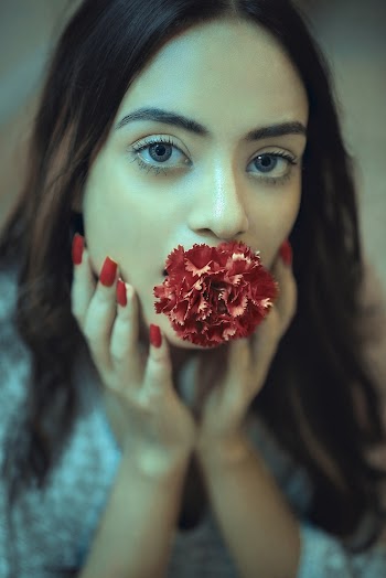 Woman Biting Red Petaled Flower