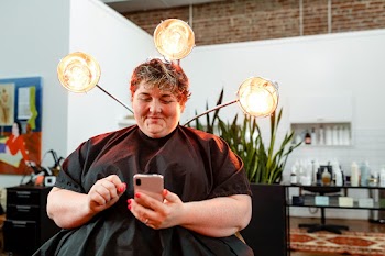 Woman browsing her phone at a salon | Free stock photo | High Resolution image