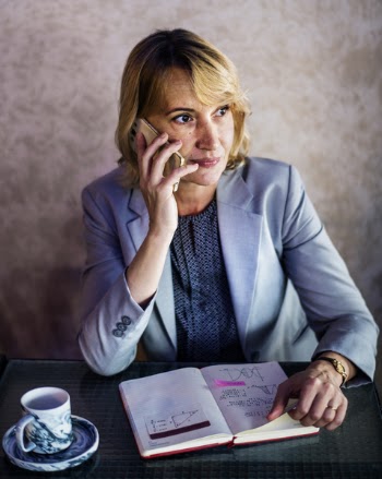 Woman Calling While Sitting in Front of Desk Behind the Wall