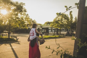 Woman Carries Child Walking on Road