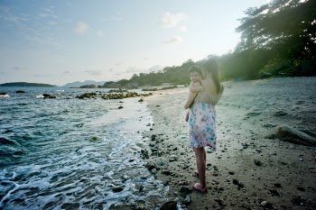 Woman Carrying Baby Beside the Seashore