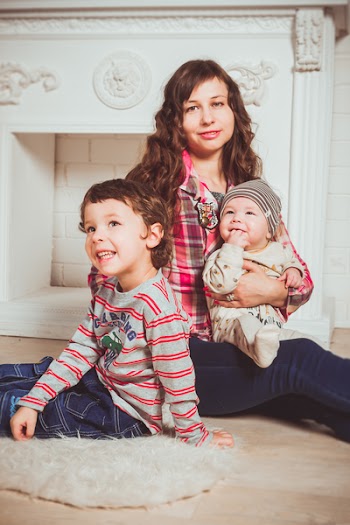 Woman Carrying Baby While Sitting Beside Little Boy