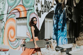 woman carrying black longboard