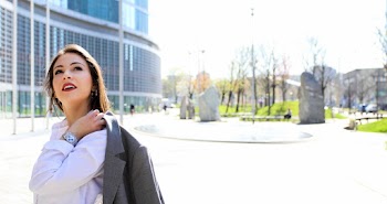 Woman Carrying Blazer Looking up on Sidewalk