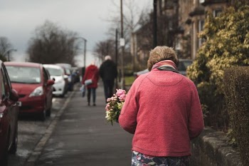 woman carrying bouquet of flower white walking on street