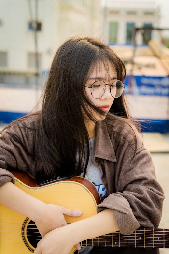 Woman Carrying Brown Guitar