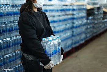 Woman carrying drinking waters with gloved hands during coronavirus pa.. | Free  photo - 2296477