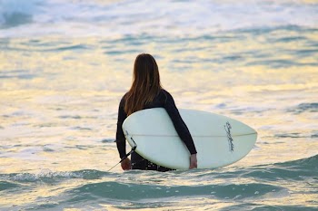 woman carrying surfboard
