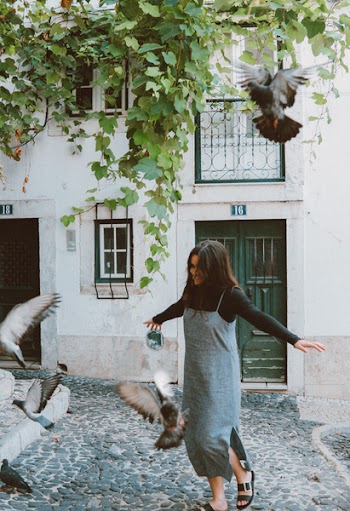 Woman Chasing Flock of Pigeons