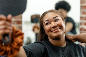 Woman checking her new hairstyle in a mirror | Free stock photo | High Resolution image